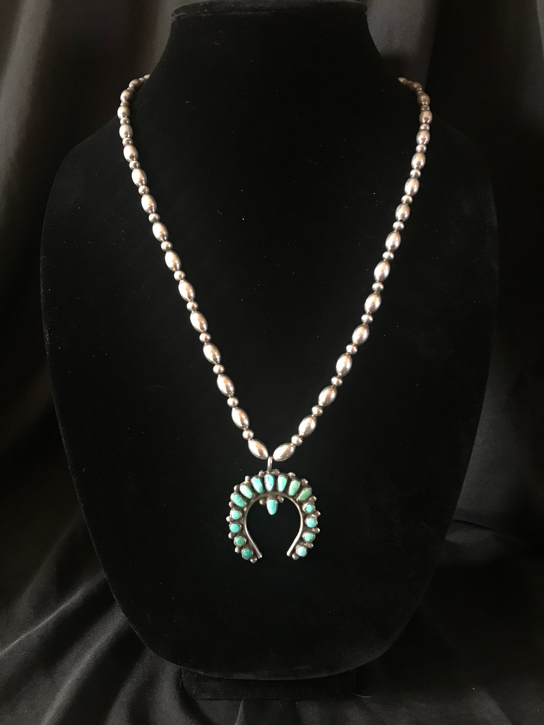 Single strand necklace of commercial silver beads with turquoise naja