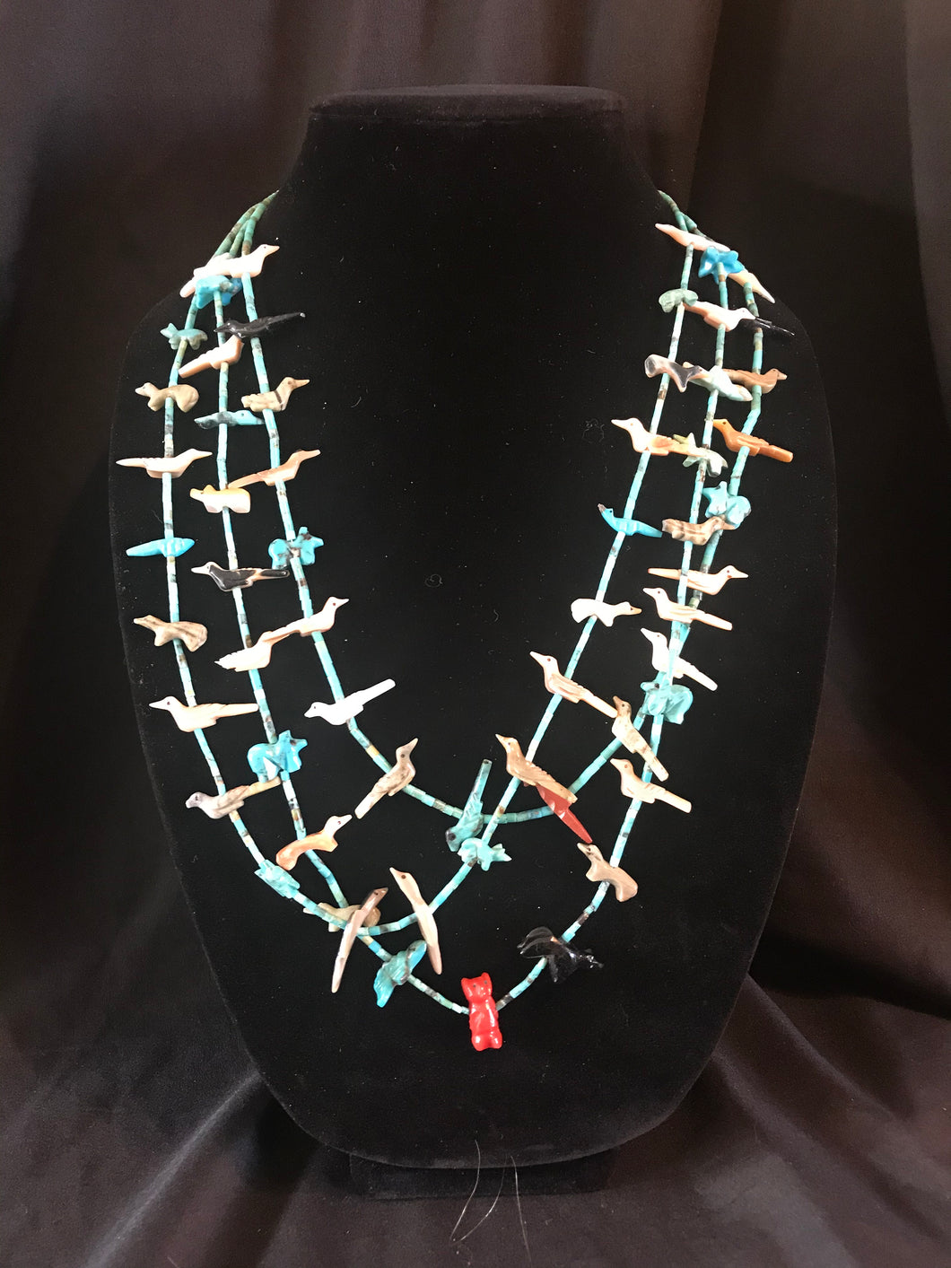 Zuni 3 strand rolled turquoise bead necklace with carved fetishes.