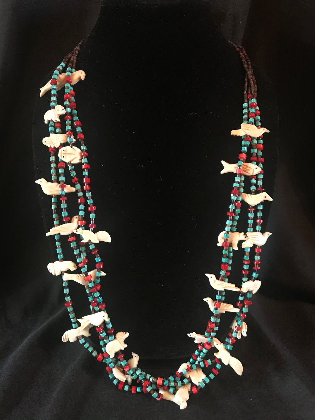 4 strand necklace with carved animals.