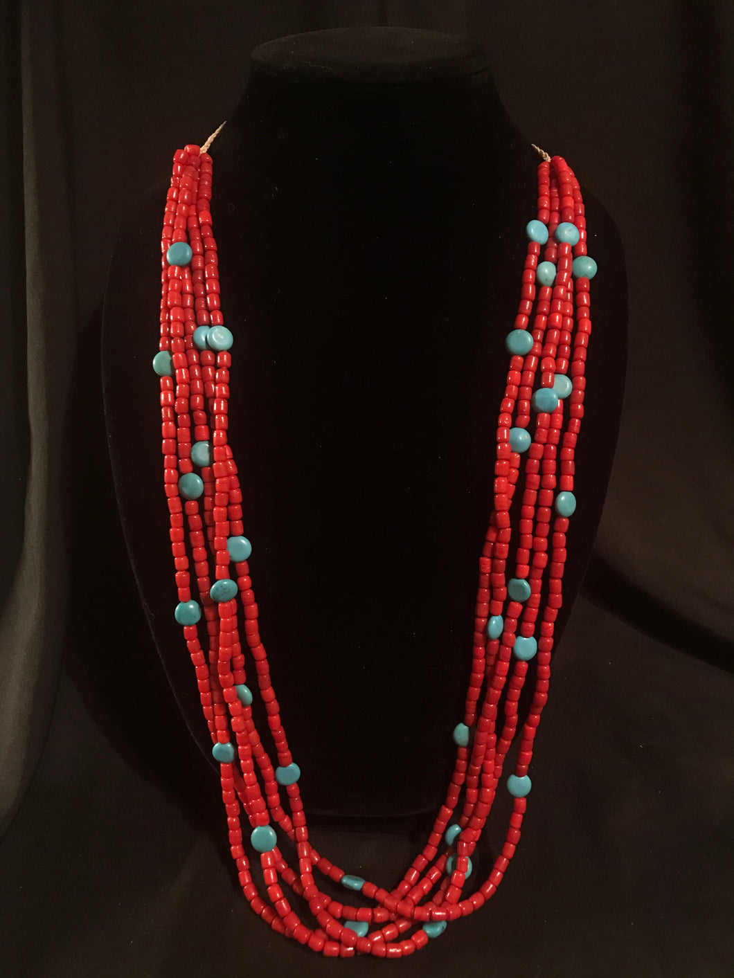Five strands of red beads interspersed with block turquoise