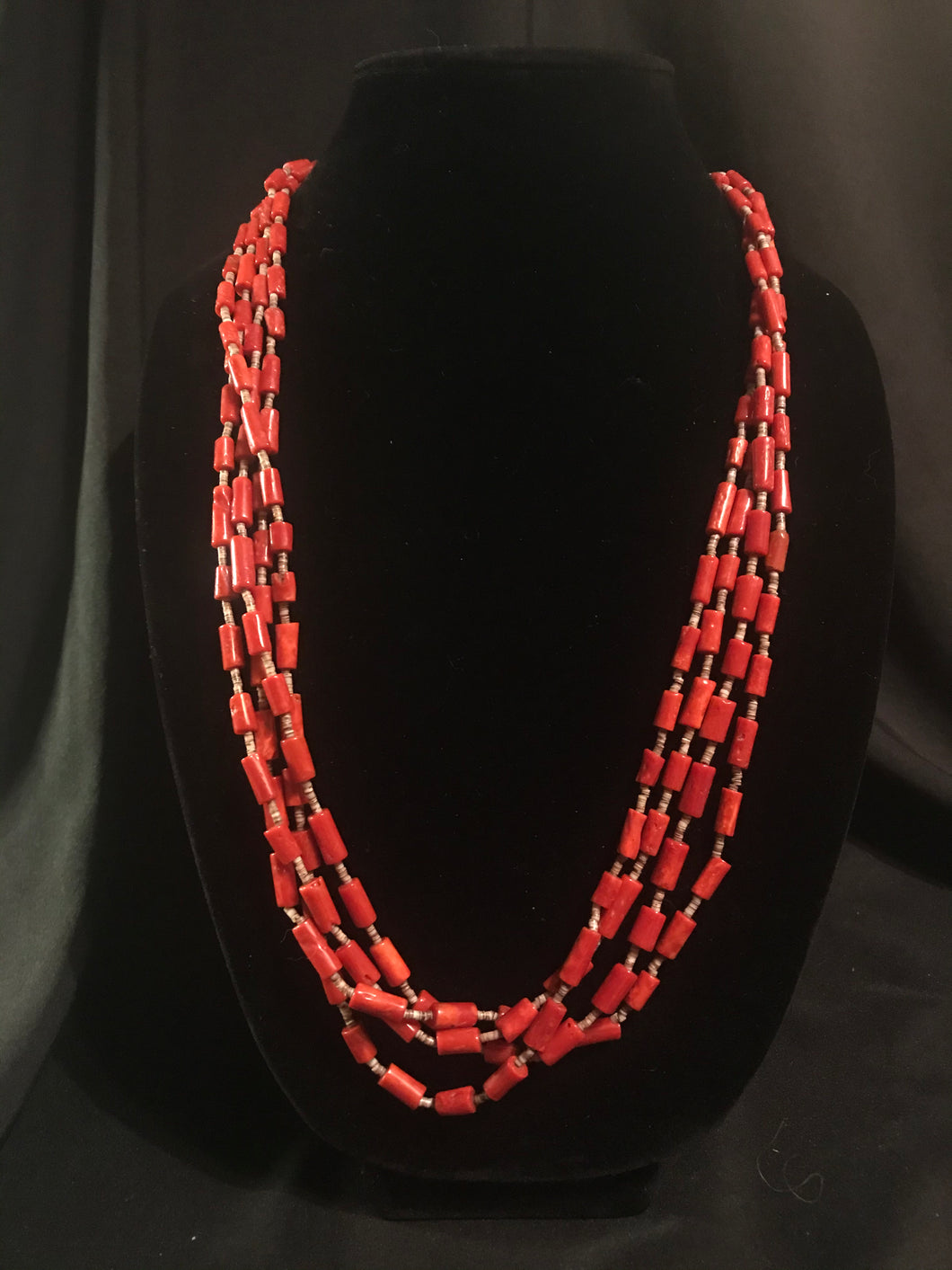 Four strand necklace of olive heishi beads interspersed with dyed red coral tube beads.