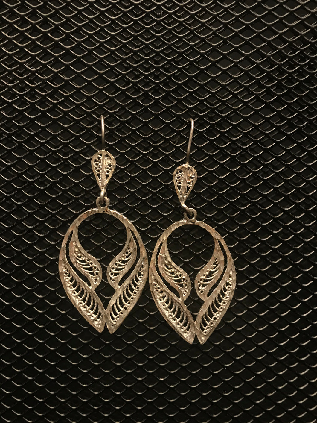 Silver colored filigree angel wings on hook earrings.